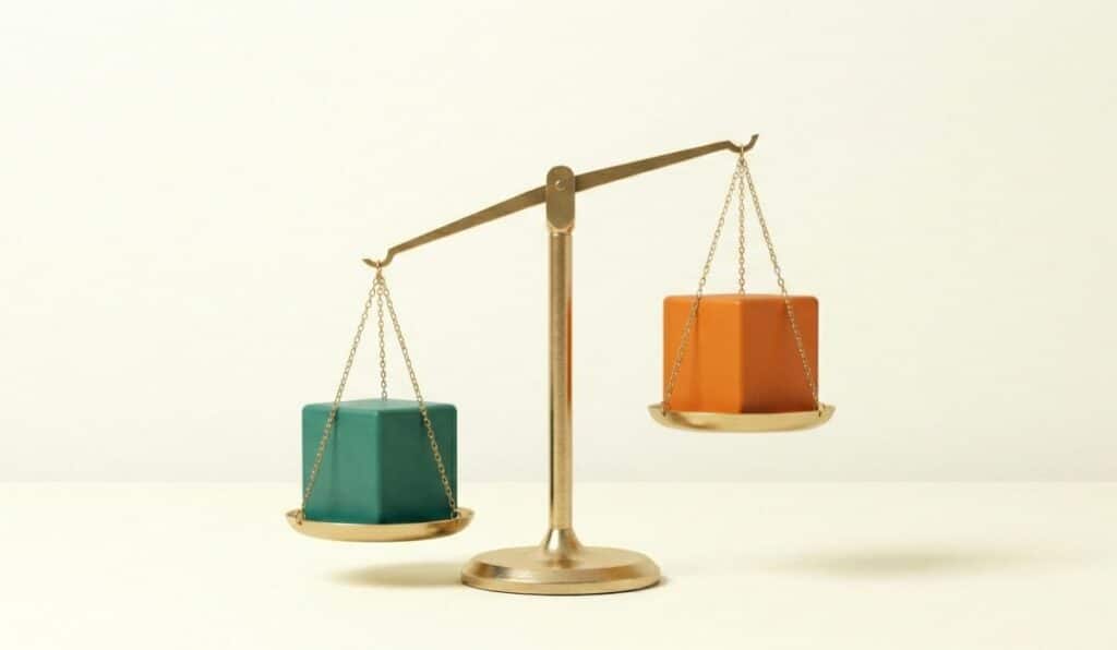 מאזניים בעלי שתי כפות הנושאות קוביות צבעוניות על רקע בהיר.